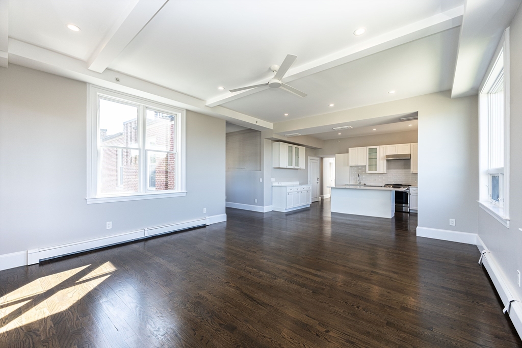 85 Regent Street, Unit 8 Boston, MA 02119 - Photo 10 of 30 a view of empty room with wooden floor and windows