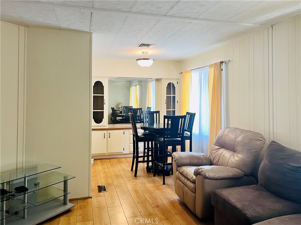 26200 Frampton Avenue, Unit 74 Harbor City, CA 90710 - Photo 11 of 19 a living room with furniture and a dining table with wooden floor