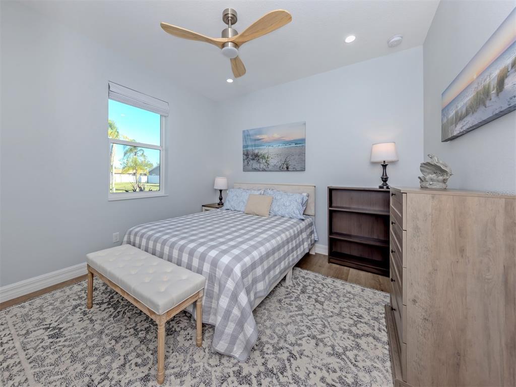 851 Linden Road Venice, FL 34293 - Photo 23 of 48 a bedroom with a bed and a lamp on table