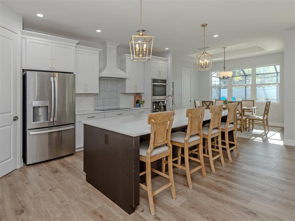 851 Linden Road Venice, FL 34293 - Photo 8 of 48 a kitchen with stainless steel appliances granite countertop a dining table chairs refrigerator and microwave