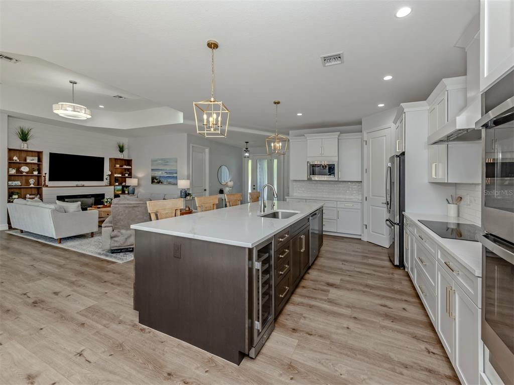 851 Linden Road Venice, FL 34293 - Photo 9 of 48 a large kitchen with stainless steel appliances lots of counter space and wooden floor