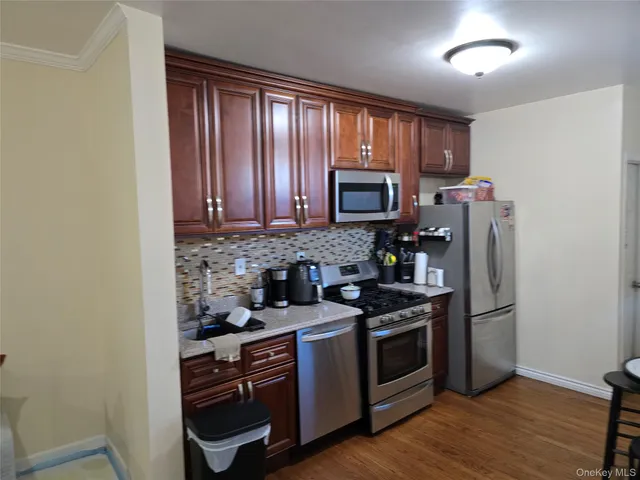 a kitchen with stainless steel appliances granite countertop a stove a microwave and a refrigerator