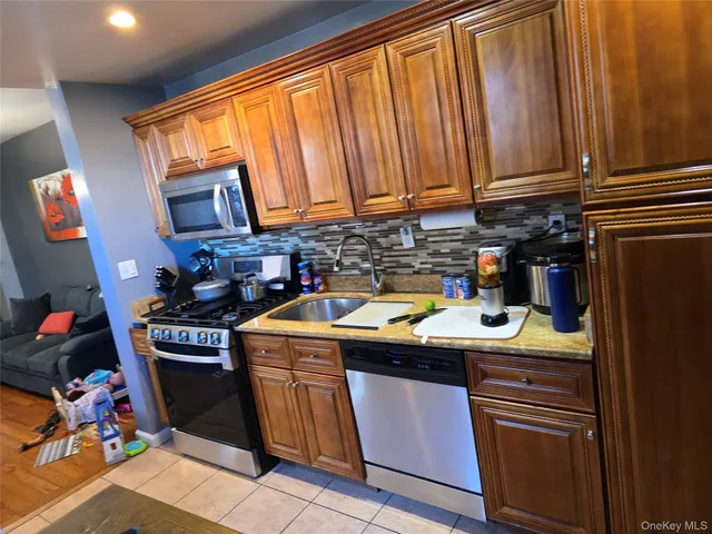 a kitchen with stainless steel appliances granite countertop a stove a sink and a microwave