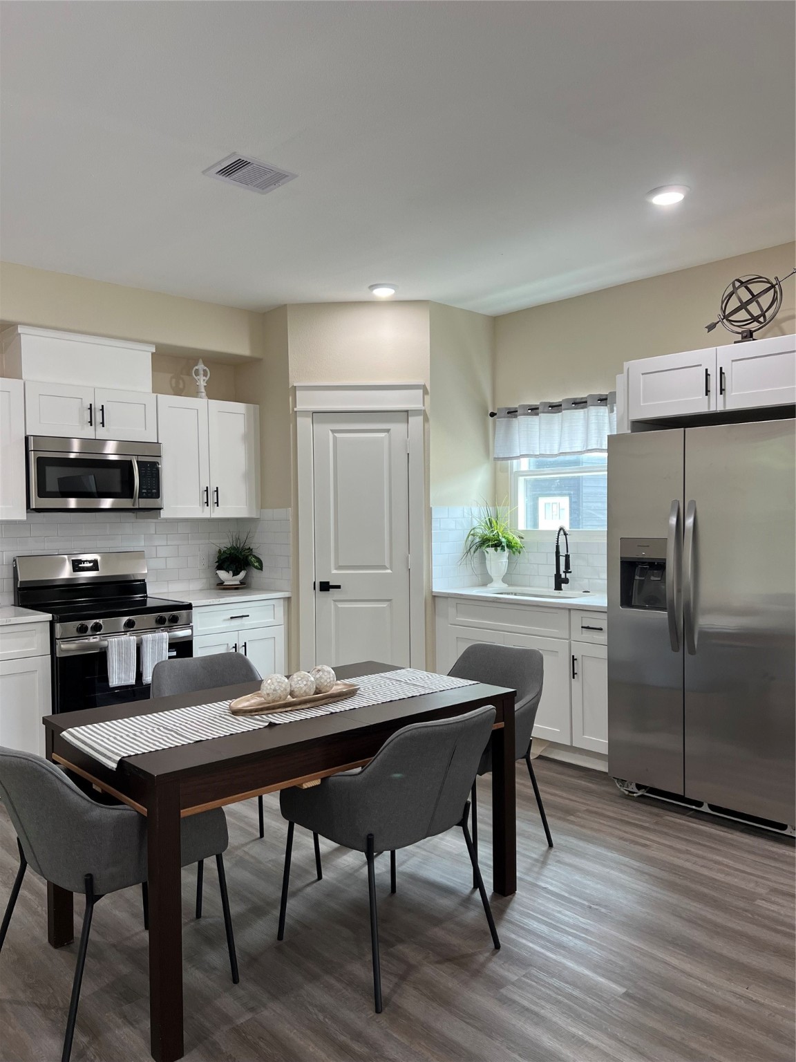 9441 Radio Road, Unit B Houston, TX 77075 - Photo 5 of 17 a kitchen with a table chairs refrigerator and cabinets