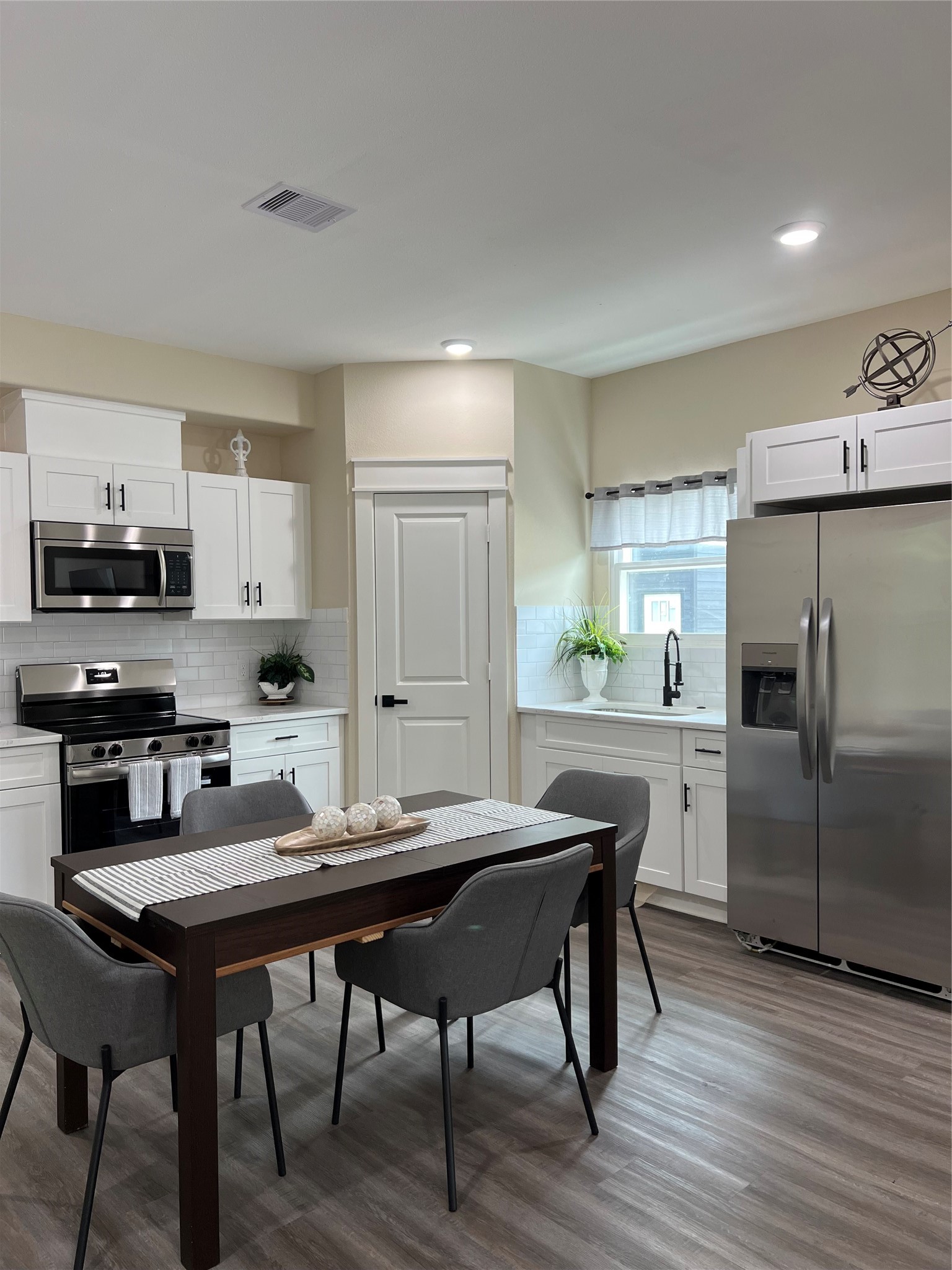 9441 Radio Road, Unit B Houston, TX 77075 - Photo 5 of 17 a kitchen with a table chairs refrigerator and cabinets