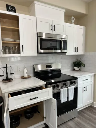 a kitchen with stainless steel appliances a stove a sink and a microwave