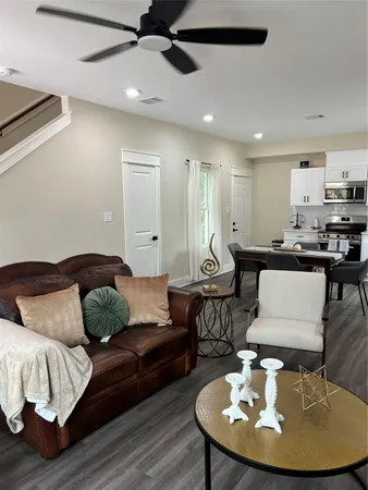 a living room with furniture and a wooden floor