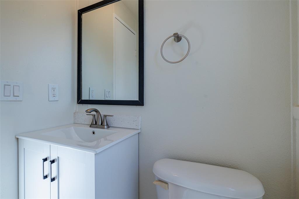 720 Jupiter Avenue Granbury, TX 76049 - Photo 14 of 23 a bathroom with a toilet sink and mirror