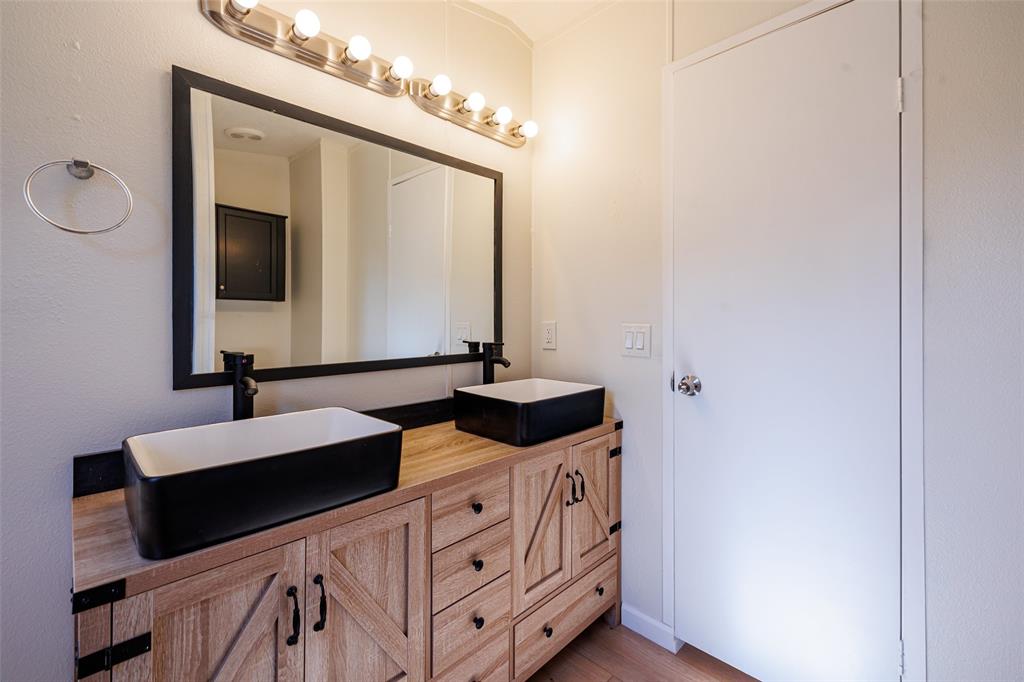720 Jupiter Avenue Granbury, TX 76049 - Photo 21 of 23 a bathroom with a double vanity sink and mirror