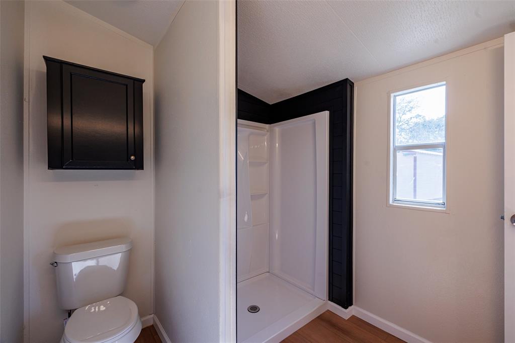 720 Jupiter Avenue Granbury, TX 76049 - Photo 23 of 23 a bathroom with a toilet sink and shower