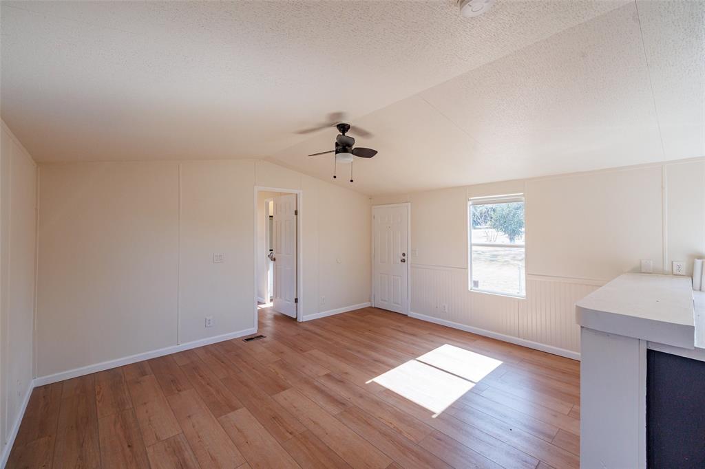 720 Jupiter Avenue Granbury, TX 76049 - Photo 5 of 23 wooden floor in an empty room with a window