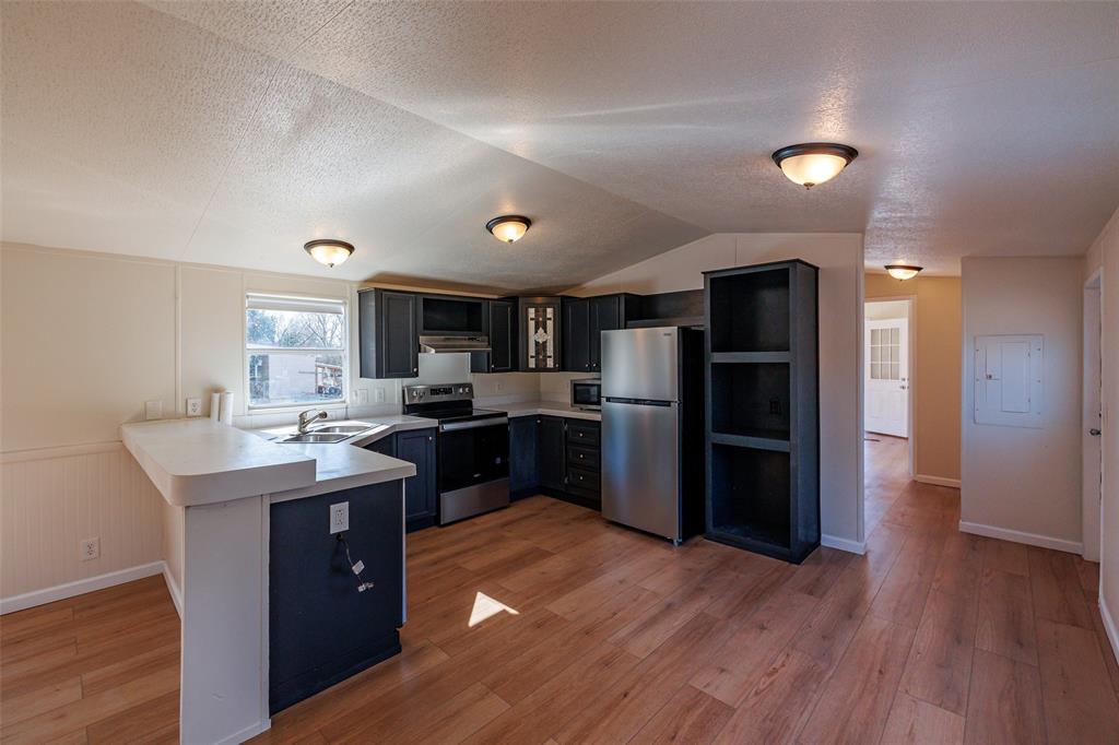 720 Jupiter Avenue Granbury, TX 76049 - Photo 6 of 23 a kitchen with refrigerator and cabinets