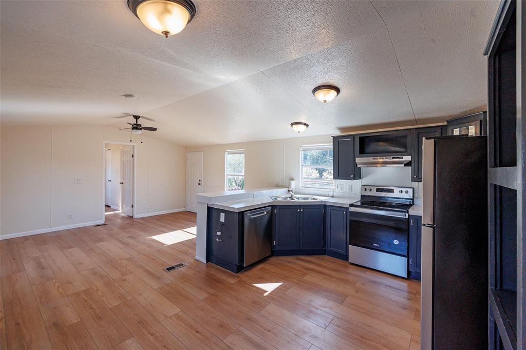 720 Jupiter Avenue Granbury, TX 76049 - Photo 7 of 23 a kitchen with stainless steel appliances granite countertop a stove refrigerator and cabinets