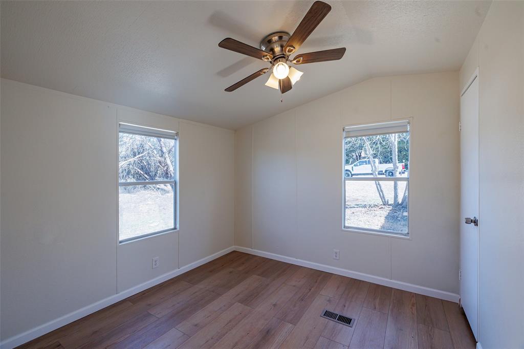 720 Jupiter Avenue Granbury, TX 76049 - Photo 10 of 23 a view of an empty room with wooden floor and a window