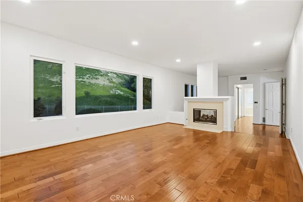 a view of empty room with wooden floor and fireplace