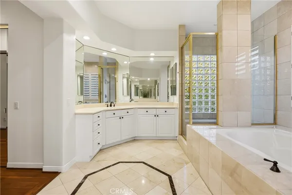 a spacious bathroom with a tub sink and mirror