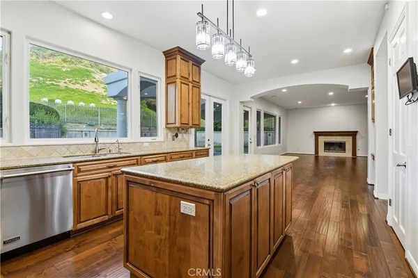 a kitchen with a sink a counter top space and stainless steel appliances