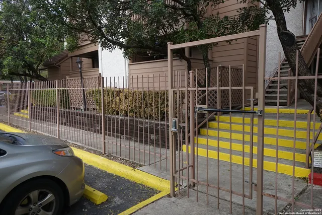 a view of a backyard with a tub and iron fence