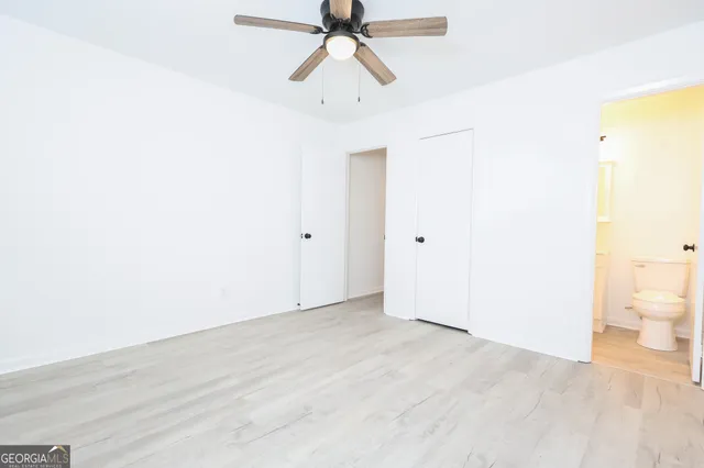 a view of a room with wooden floor and a ceiling fan