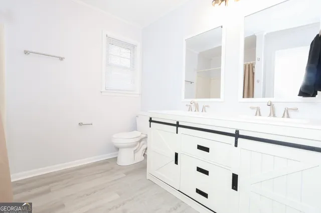 a bathroom with a sink a toilet and a mirror