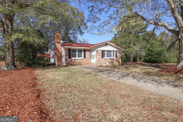 a front view of a house with a yard and trees