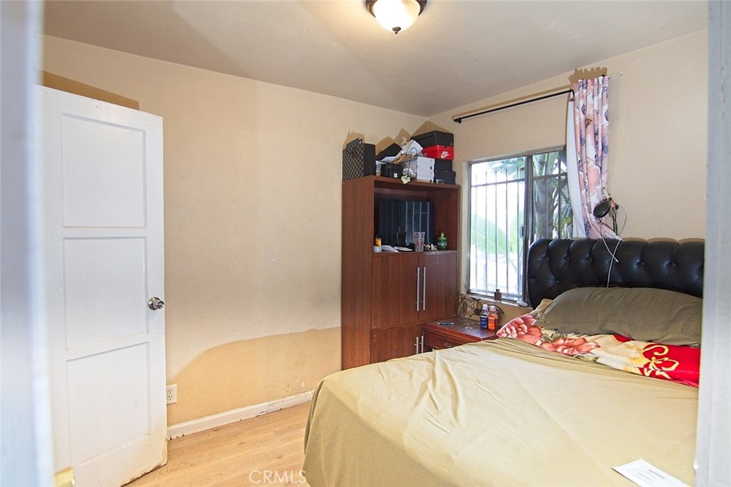 6905 Compton Avenue Los Angeles, CA 90001 - Photo 5 of 26 a bedroom with a bed and a refrigerator