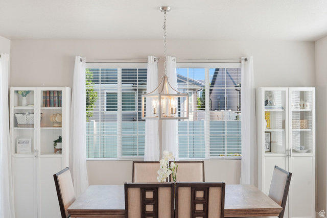 3244 West 1670th Street North Provo, UT 84601 - Photo 19 of 56 Central dining area with a modern drum chandelier, featuring a large window with white blinds and sheer curtains