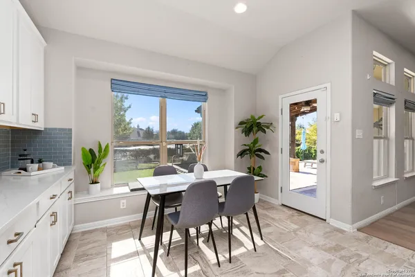 a kitchen with a table chairs and window