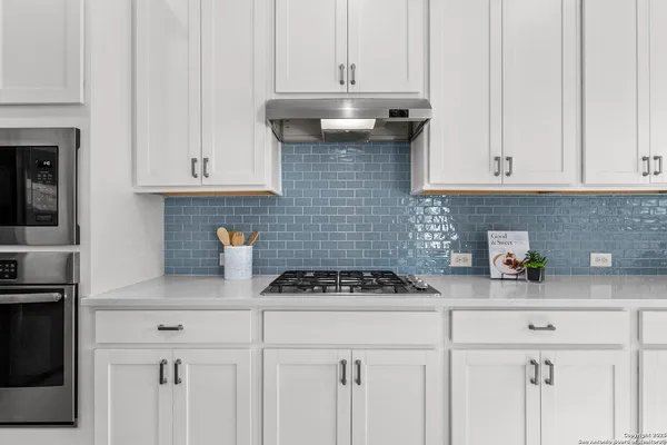 a kitchen with white cabinets and a stove