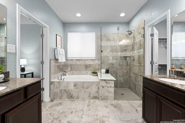 a bathroom with a granite countertop sink mirror bathtub and shower