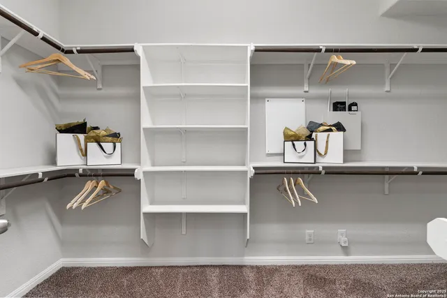 a view of walk in closet with empty racks
