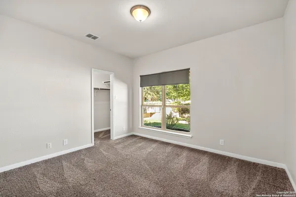 an empty room with windows and closet