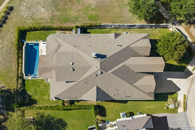 an aerial view of a house with a garden and lake view