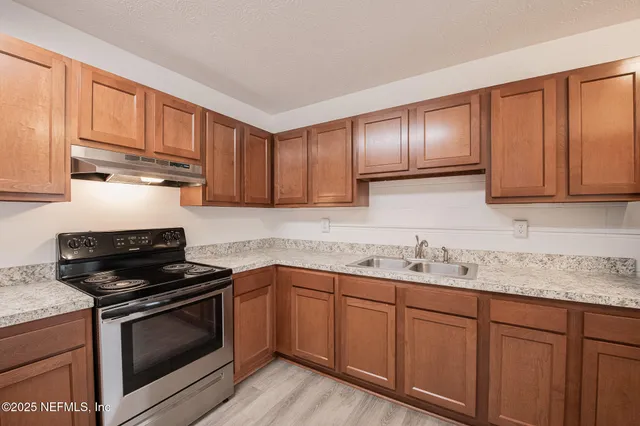 a kitchen with stainless steel appliances granite countertop a refrigerator a sink and dishwasher