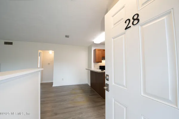 a view of an empty room with wooden floor