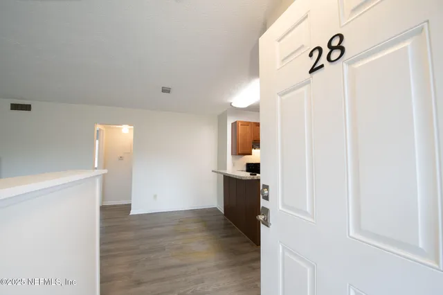 a view of an empty room with wooden floor
