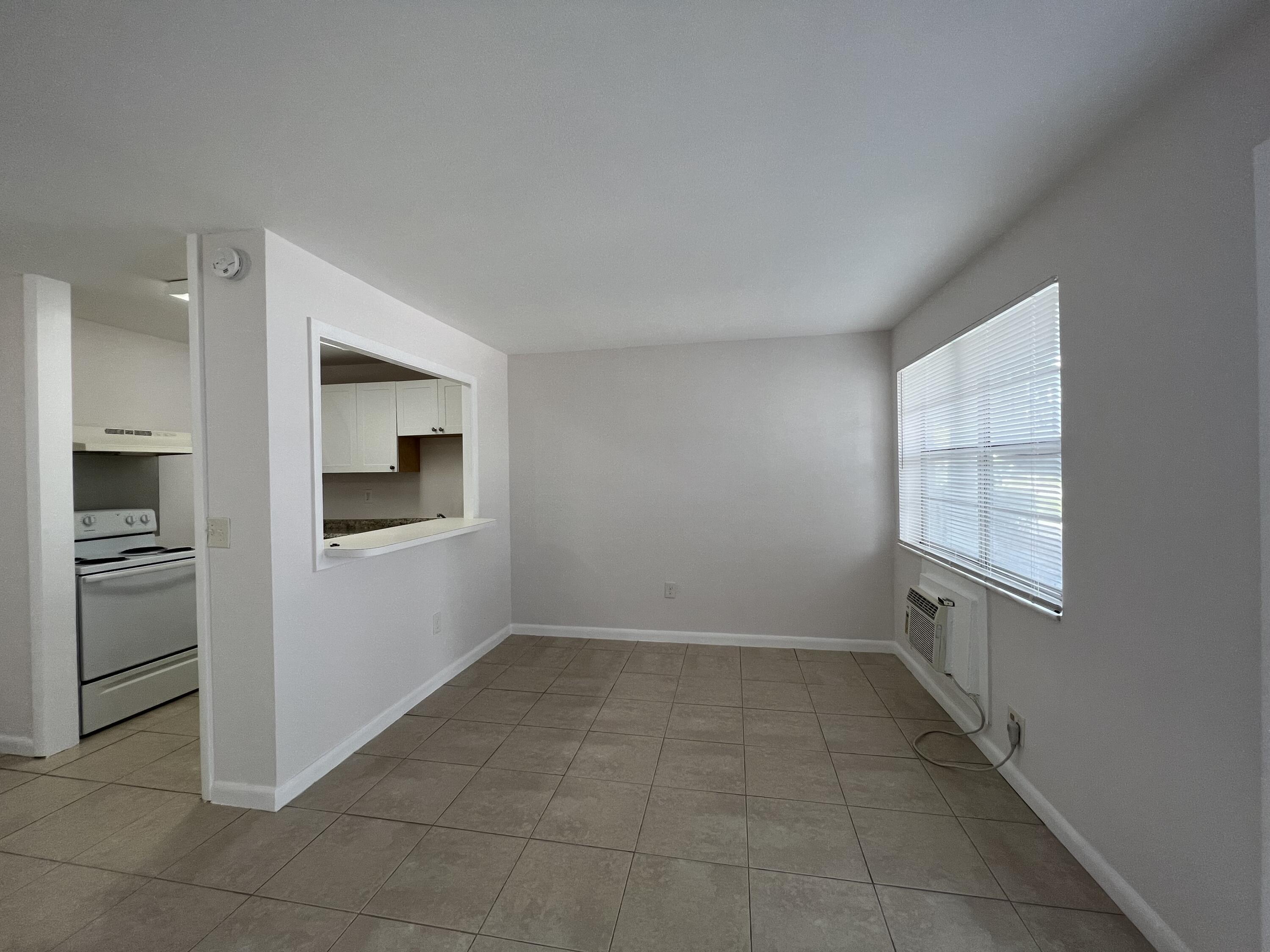 a view of an empty room with a kitchen