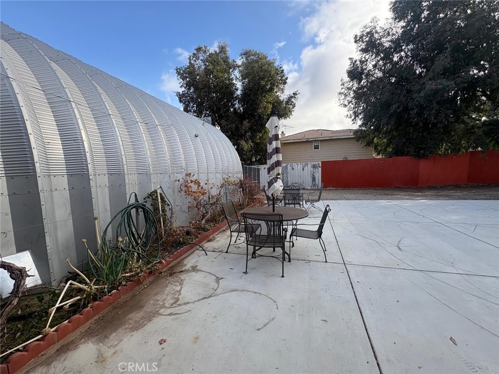 42150 Margoni Way Hemet, CA 92544 - Photo 6 of 10 a view of a patio with table and chairs with wooden fence and plants
