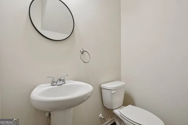 a bathroom with a sink a toilet and a mirror