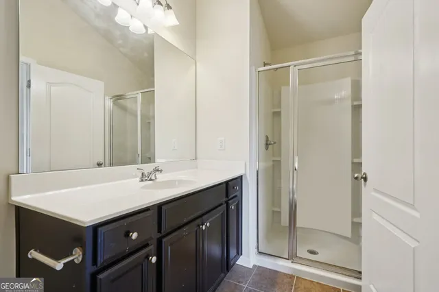 a bathroom with a shower sink vanity and mirror