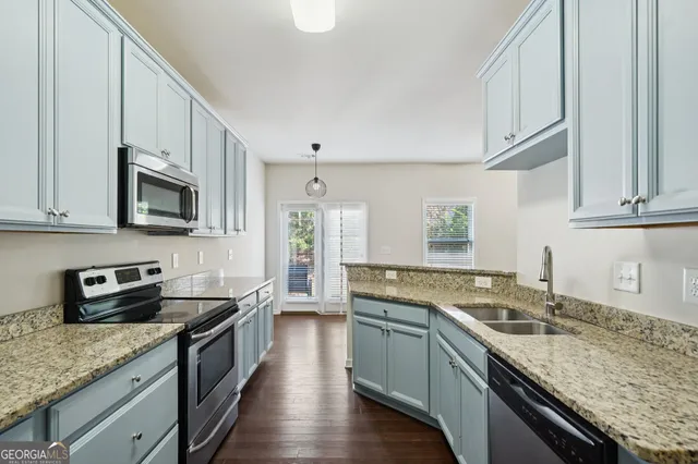 a kitchen with stainless steel appliances granite countertop a sink stove microwave and cabinets