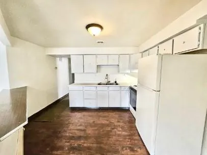 a large white kitchen with a refrigerator a sink and a stove