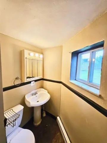 a bathroom with a sink a toilet and mirror