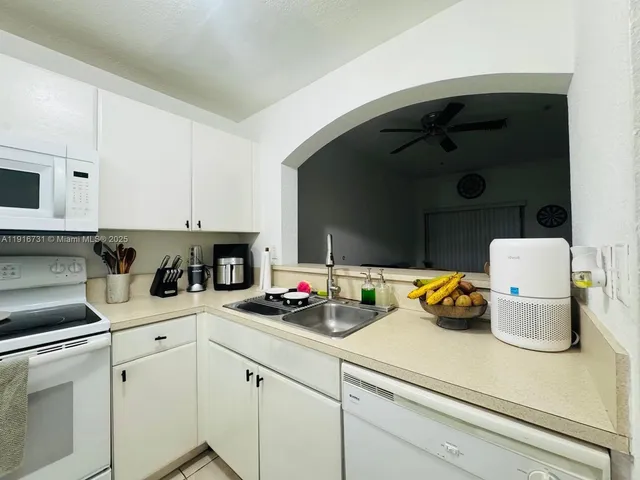 a kitchen with a sink a stove and cabinets