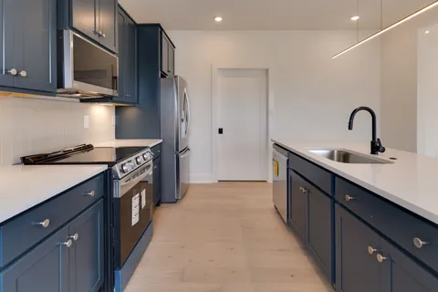 a kitchen with stainless steel appliances a sink stove and cabinets