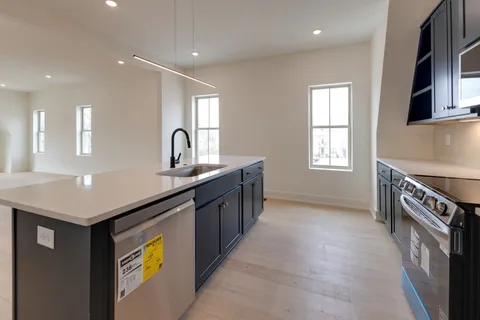 a kitchen with kitchen island granite countertop a sink counter top space and cabinets