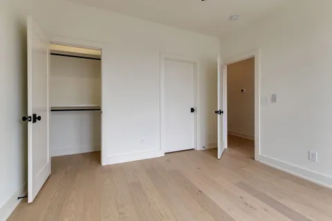 an empty room with closet and wooden floor
