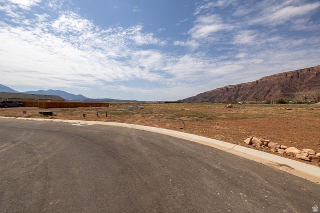 212 Lidia Circle, Unit 17 Moab, UT 84532 - Photo 10 of 24 Expansive land parcel featuring existing paved road frontage, curb and gutter infrastructure, and mountain vistas