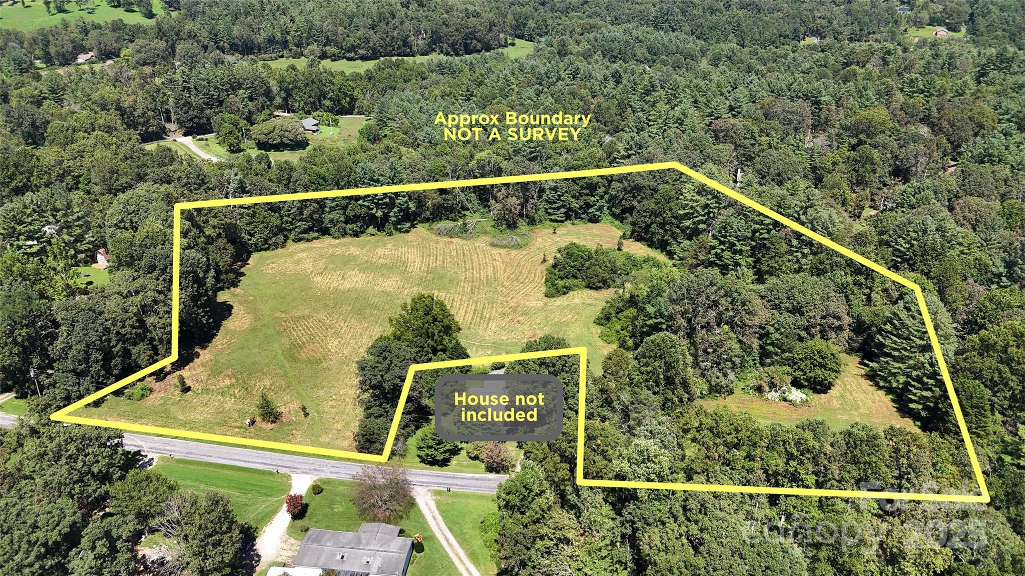 an aerial view of a house with a yard and large trees