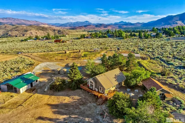 an aerial view of residential houses with outdoor space and trees
